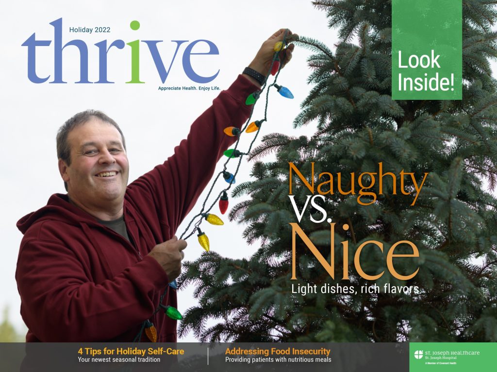 A cover of the holiday issue of thrive magazine, featuring a man putting lights on a Christmas tree.